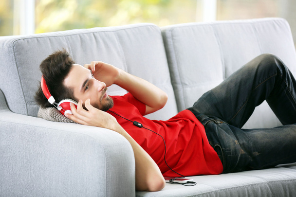 Young man listens music with headphones  - Fotó, kép
