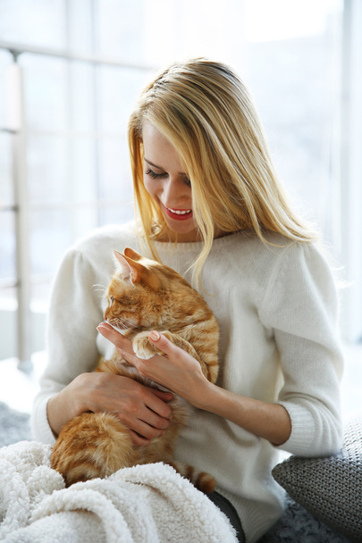 Young woman posing with red cat - Photo, image