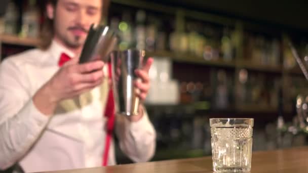 Bijna klaar. Jonge professionele barman serveren een drankje in de lokale bar - Video