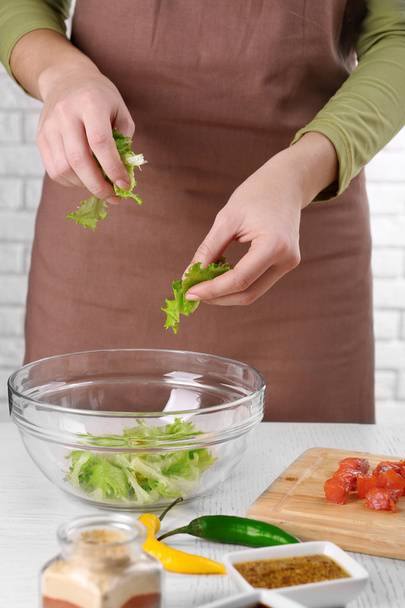 Female hands adding lettuce leaves  - Фото, зображення