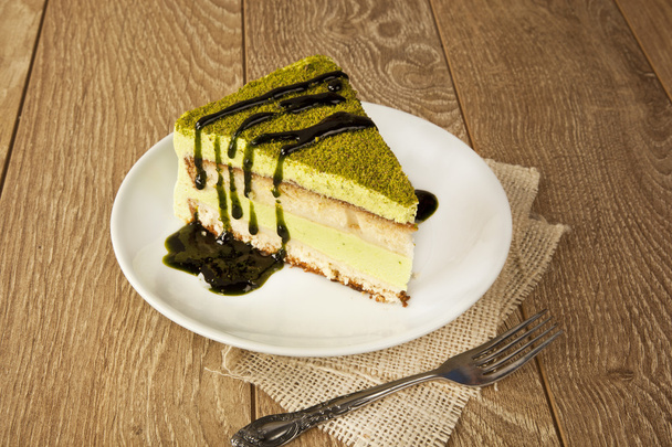 Pisztácia sajttorta mousse torta dió mintával egy fából készült asztal - Fotó, kép