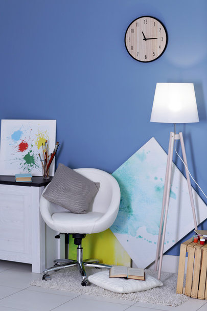 Room design with white furniture, pictures, clock and floor lamp over blue wall - Fotó, kép