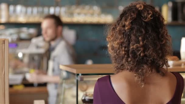 Meisje glimlachen op de achtergrond van mannelijke barista - Video