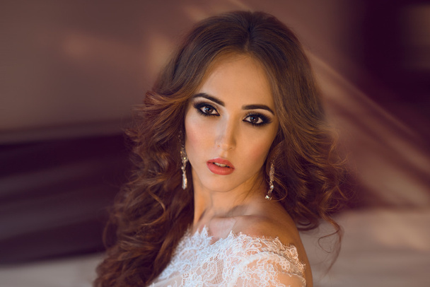 Portrait of beautiful brunette bride with ceremony make-up and curly hair - Fotoğraf, Görsel