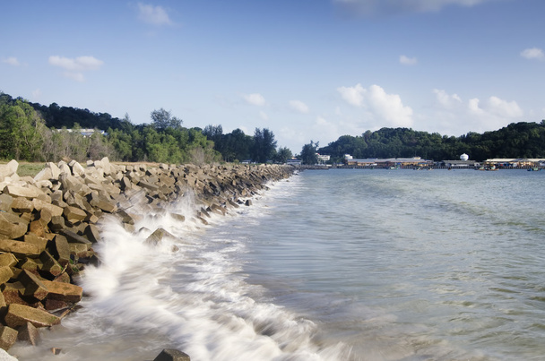 concrete breakwater along the coastline to protect mainland from heavy waves - Photo, Image