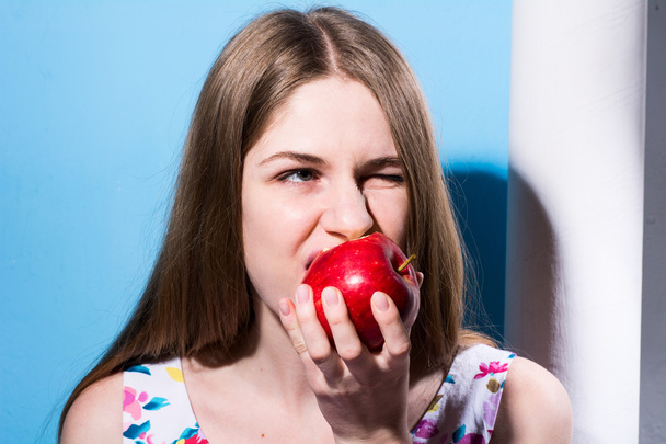 Közeli kép: egy lány, eszik egy piros Alma - Fotó, kép