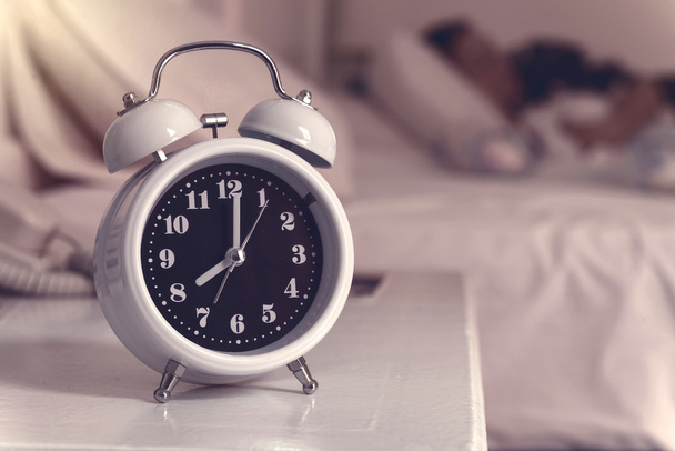 alarm clock on the bed in bedroom, retro style - Φωτογραφία, εικόνα