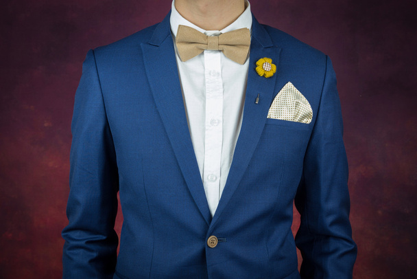 homme en costume bleu noeud papillon, broche, mouchoir
 - Photo, image