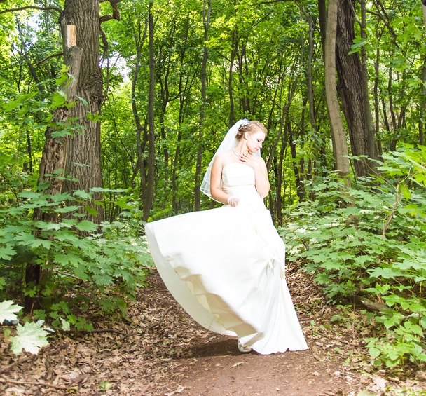 Novia ondeando vestido en un bosque
 - Foto, imagen