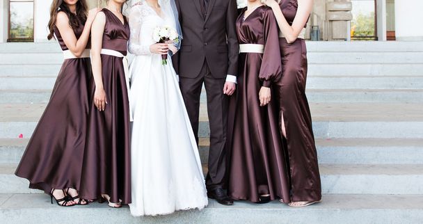 beau marié en costume étreignant mariée élégante avec demoiselles d'honneur
 - Photo, image