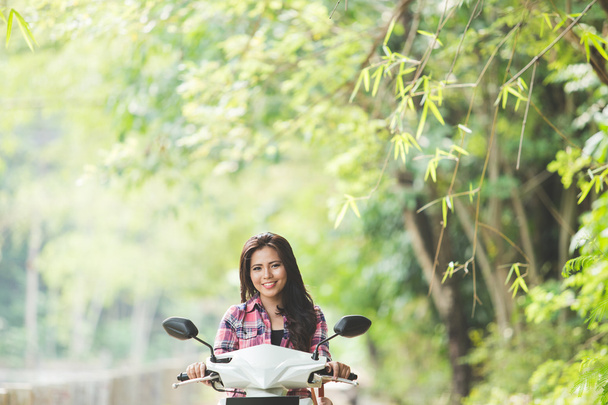 Young Asian woman riding a motorcycle - Foto, afbeelding