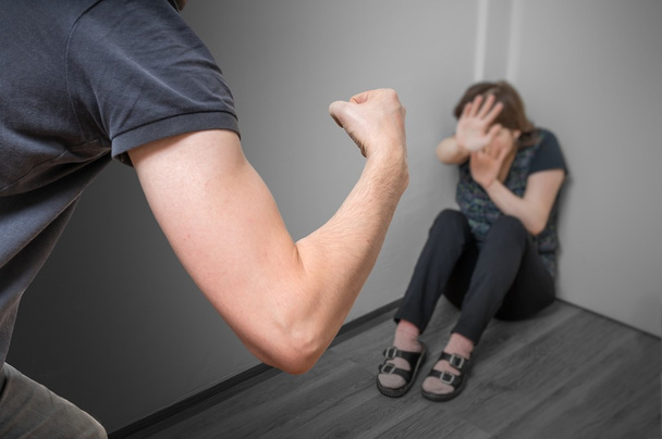Концепція домашнього насильства. Ревнивий чоловік зловживає своєю дружиною кулаком
. - Фото, зображення