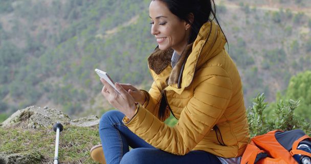 жіночий пішохід використовує телефон в горах
 - Фото, зображення