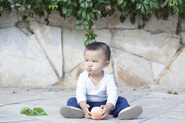 Милый китайский мальчик ест яблоко
 - Фото, изображение