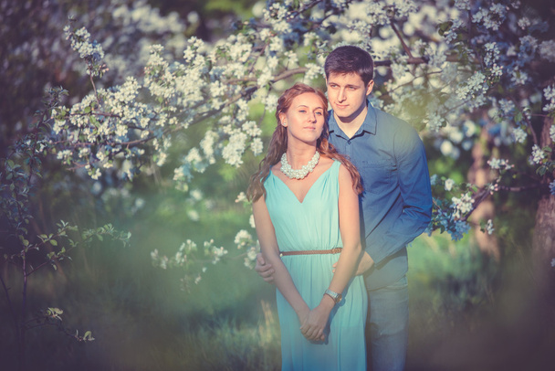 Jovem belo casal apaixonado entre macieiras
 - Foto, Imagem