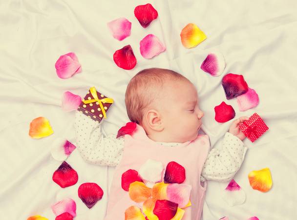 Pequeno bebê com pétalas de rosa
  - Foto, Imagem