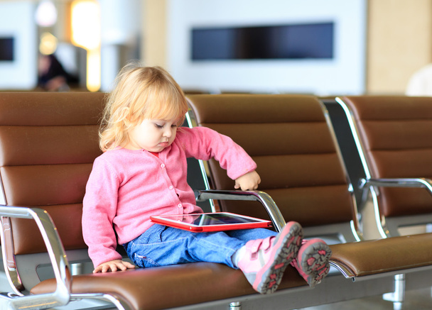 маленькая девочка смотрит на сенсорную панель в аэропорту
 - Фото, изображение