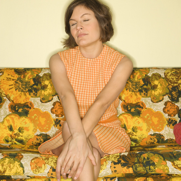 Woman sitting on sofa. - Foto, afbeelding