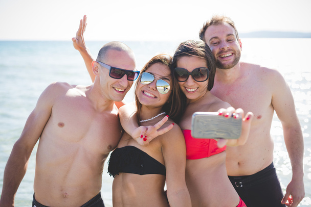 amigos multiétnicos en la playa tomando selfie
 - Foto, Imagen
