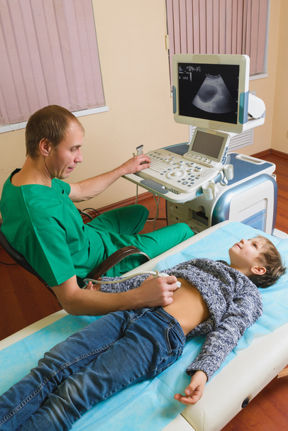 Doctor analyzing boy patient with abdomen ultrasound - Photo, Image