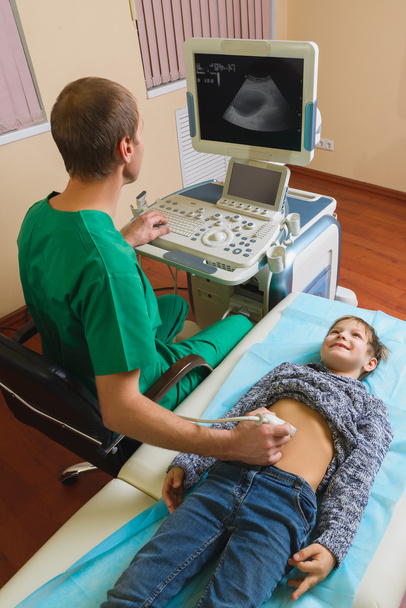 Doctor analyzing boy patient with abdomen ultrasound - Photo, Image