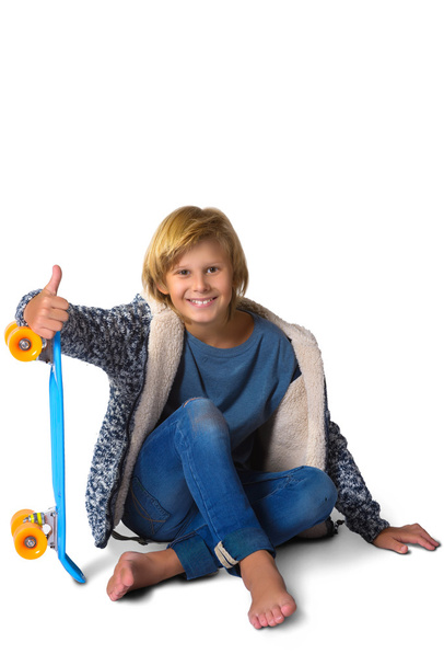 Cute blonde boy or teenager in full length casual style blue jeans posing with skateboard pennyboard isolated on white - Photo, Image
