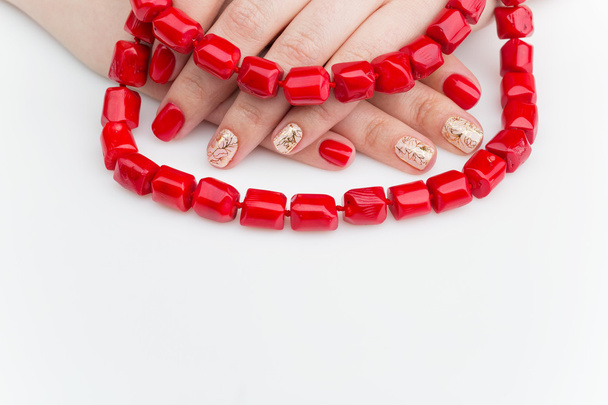 Vrouw handen met rode en gouden manicure - Foto, afbeelding
