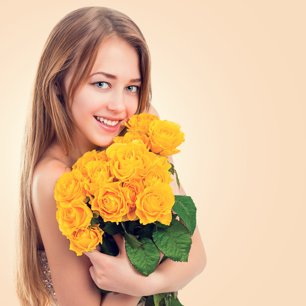 Portrait of a beautiful young woman with a bouquet of yellow roses - Fotografie, Obrázek