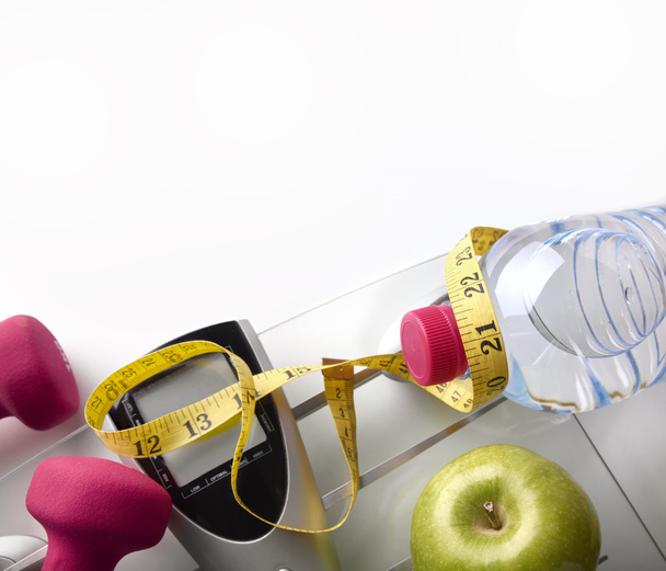 Scale with dumbbells bottle apple and tape measure top - Zdjęcie, obraz