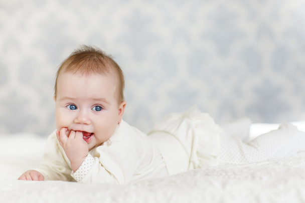 Portrait of a crawling baby on the bed in her room - Фото, изображение