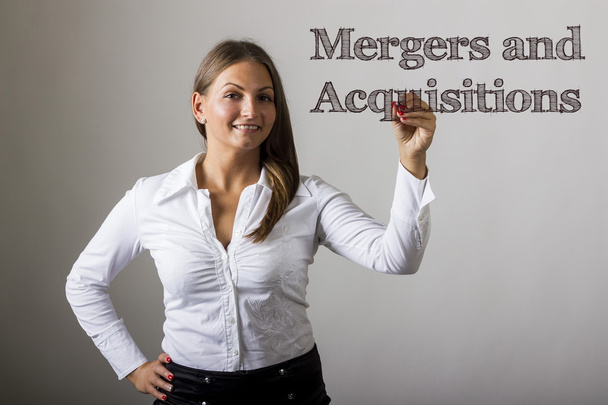 Mergers and Acquisitions - Beautiful girl writing on transparent - Photo, Image