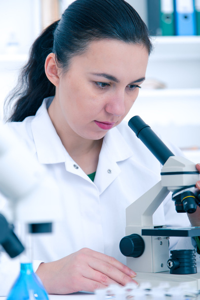 Femme travaillant avec un microscope dans un labo.
 - Photo, image