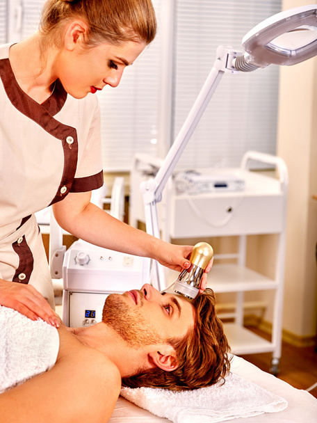 Jovem recebendo massagem facial elétrica
. - Foto, Imagem