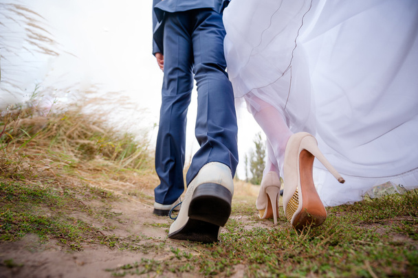 Jambes mariées et marié, les jeunes mariés marchent à l'extérieur
 - Photo, image