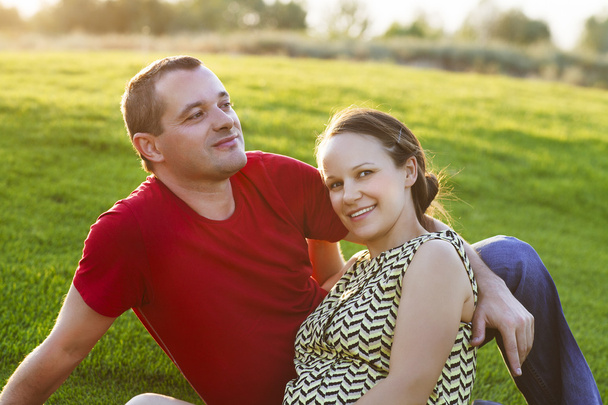 Happy pregnant woman with her husband at sunset - Фото, зображення