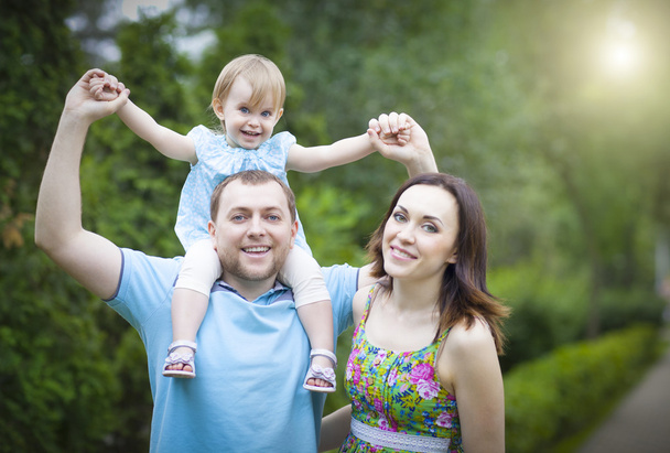 Happy young family with baby girl spending time outdoor - Foto, Imagen