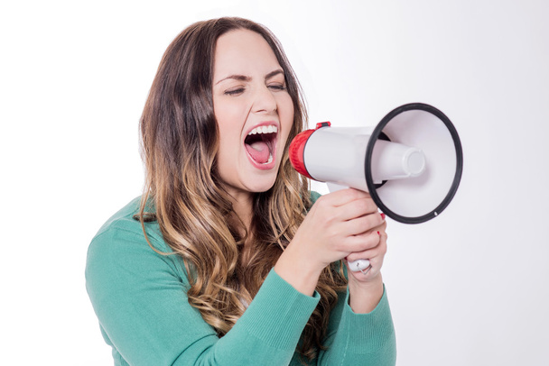 Young woman shouting into a megaphone - Photo, Image