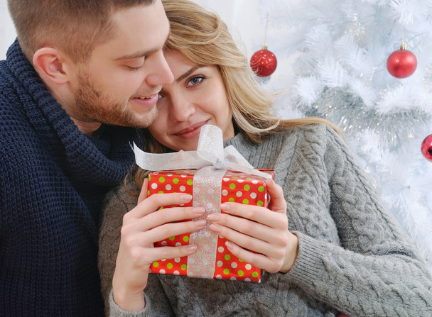 joyful nice girl in the arms of a boyfriend with christmas gifts - Photo, Image