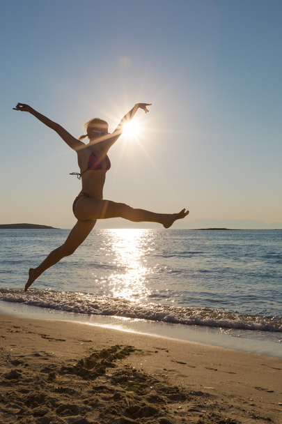 Mulher pulando backlight na praia
 - Foto, Imagem