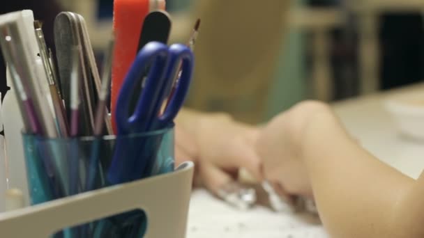 Manikiurzystka mistrza w salonie pokrywa paznokcie w folii - Materiał filmowy, wideo