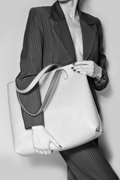 Fashion model with bag over grey background - Foto, afbeelding