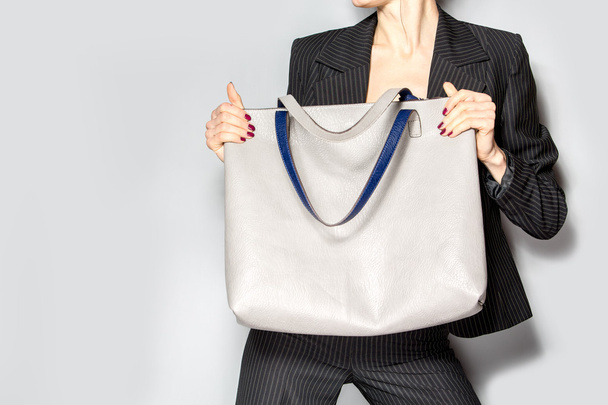 Fashion model with bag over grey background - Фото, изображение