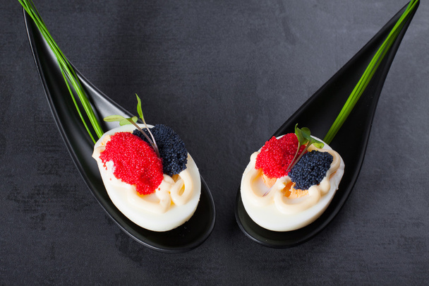 Appetizer on fingerspoon egg with caviar with copy space. - Photo, Image