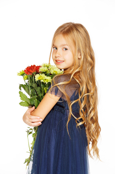 Beautiful little girl with a bouquet of flowers - Фото, изображение