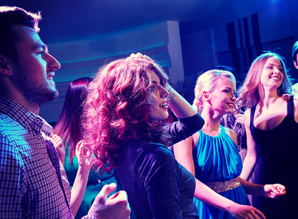 smiling friends dancing in club - Фото, изображение