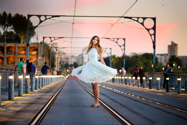 woman stands on a bridge at sunset - Photo, image
