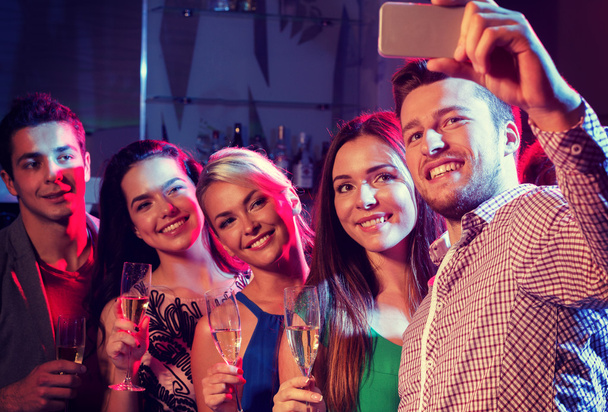 friends with glasses and smartphone in club - Foto, Bild