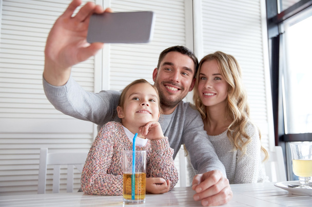 happy family taking selfie at restaurant - Foto, afbeelding