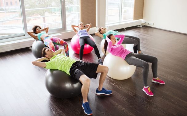 happy people flexing abdominal muscles on fitball - Foto, immagini