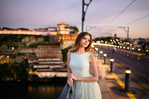 woman stands on a bridge at sunset - 写真・画像